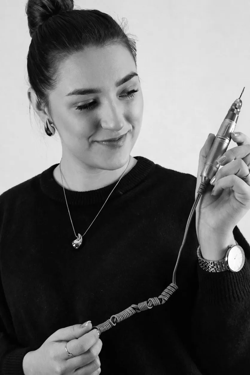 Retrato a preto e branco da Diana, nail designer, a segurar a broca elétrica que usa nas unhas.